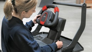 Operator of an order picker adjusts the Linde steering wheel to her height