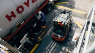 A Linde forklift truck with an explosion-proof design stands next to a tanker with chemicals.