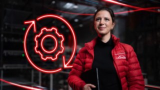 Linde Material Handling employee in a warehouse with a red LED gear wheel symbol in the background.