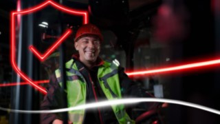 Person with work clothes and hard hat sitting in a Linde forklift truck