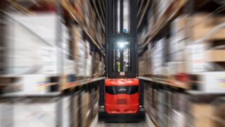 A very narrow aisle truck from Linde Material Handling in use in a warehouse.