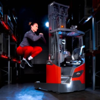 Athlete jumping high beside the Linde reach truck Ri16.