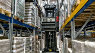 The Linde K-MATIC automated very narrow aisle truck driving through a rack aisle.