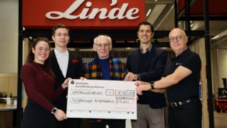 StaplerCup hilft e.V. presents a donation to Aschaffenburger Kinderträume Five people standing together holding a large cheque addressed by Linde to Aschaffenburger Kinderträume for the sum of 10,000 euros.